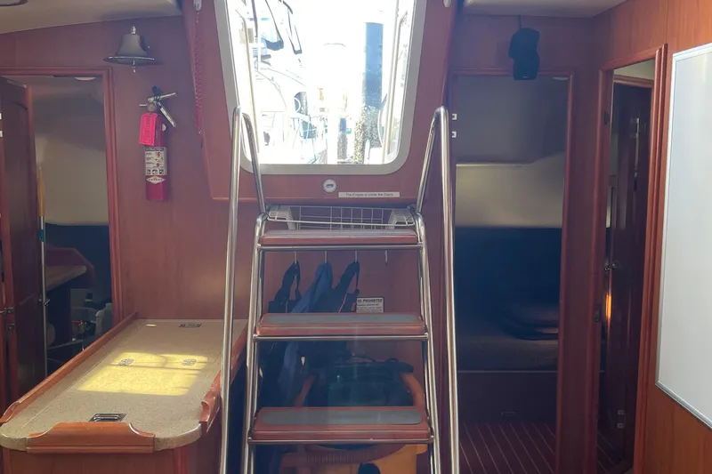  Yacht Photos Pics Interior of a 2008 Hunter 49 sailboat with stairs and wooden cabinetry.