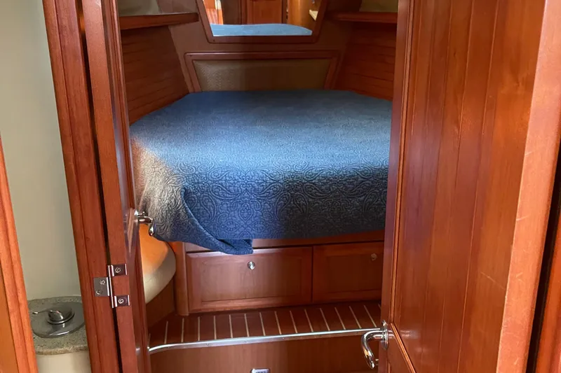  Yacht Photos Pics Cozy cabin interior of 2008 Hunter 49 yacht with wooden finish and blue bedding.