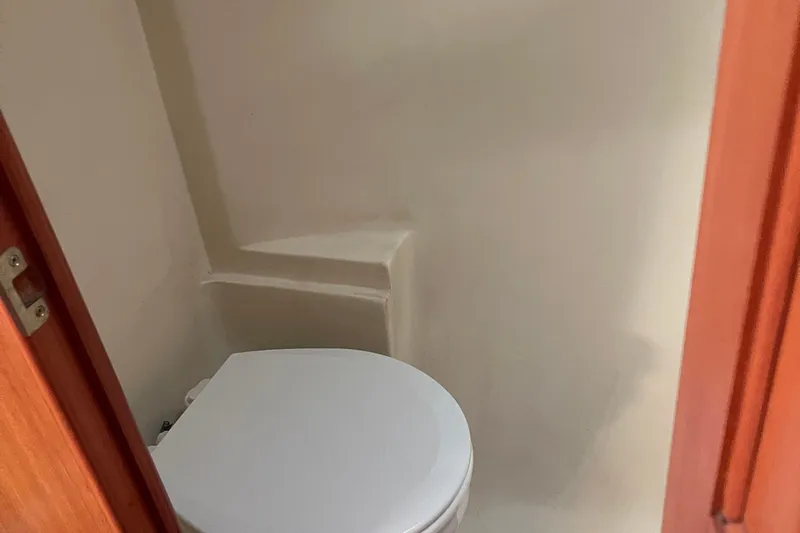  Yacht Photos Pics Compact bathroom in a 2008 Hunter 49 yacht, featuring a white toilet and wooden door.