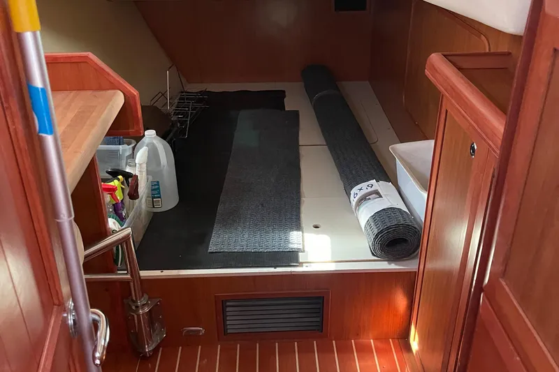  Yacht Photos Pics Interior of a 2008 Hunter 49 sailboat with cleaning supplies and rolled carpet.