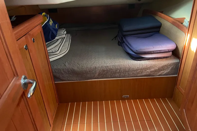  Yacht Photos Pics Cozy cabin interior of 2008 Hunter 49 sailboat with wooden finish and bedding.