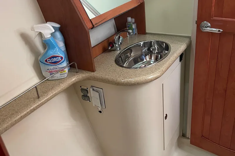 Yacht Photos Pics Compact bathroom sink area in a 2008 Hunter 49 yacht, featuring cleaning supplies.