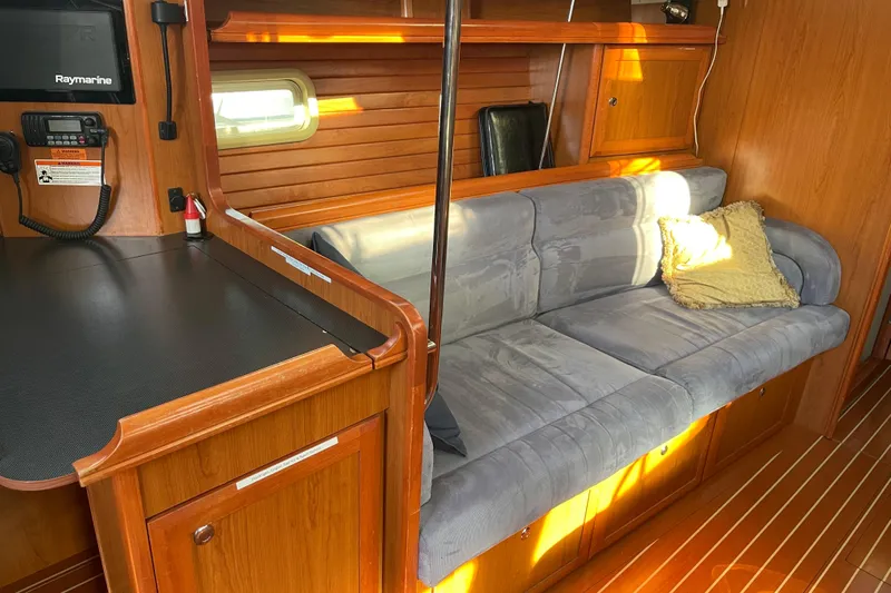  Yacht Photos Pics Interior of 2008 Hunter 49 yacht with wooden cabinetry and a cushioned sofa.