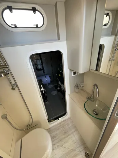  Yacht Photos Pics Luxurious bathroom on 2019 Absolute 62 Fly yacht with modern fixtures and porthole window.