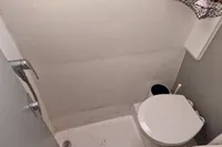 Compact bathroom in a 1996 Custom Catamaran 60', featuring a toilet and shower.
