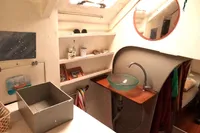 Interior of 1996 Custom Catamaran 60' with glass sink, shelves, and round mirror.