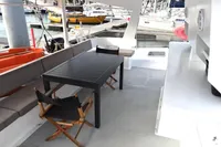 Outdoor seating area on a 1996 Custom Catamaran 60', docked at a marina.