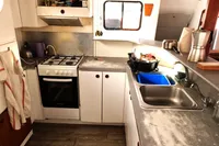 Kitchen area of a 1996 Custom Catamaran 60', featuring stove and dual sinks.