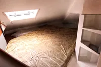Cozy cabin interior of 1996 Custom CATAMARAN 60', featuring a bed and storage shelves.