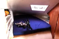 Cozy cabin interior of 1996 Custom Catamaran 60', featuring a bed and fishing gear.