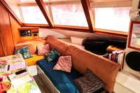 Cozy interior of 1996 Custom Catamaran 60' with colorful cushions and wooden accents.