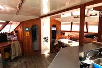Interior of 1996 Custom Catamaran 60' with wooden decor and cozy seating area.