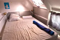 Cozy cabin interior of 1996 Custom Catamaran 60', featuring a bed and nautical decor.