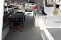 Spacious deck of 1996 Custom Catamaran 60', featuring seating and table setup.