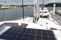1996 Custom CATAMARAN 60' with solar panels docked in a scenic harbor.