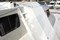 White 1996 Custom Catamaran 60' with exterior stairs and window, docked at marina.