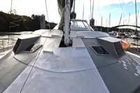 Custom 60' catamaran from 1996 docked, showcasing sleek deck design and marina backdrop.