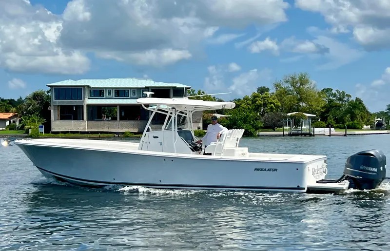 Redemption Yacht Photos Pics 2012 Regulator 34SS boat cruising on a sunny day near waterfront homes.