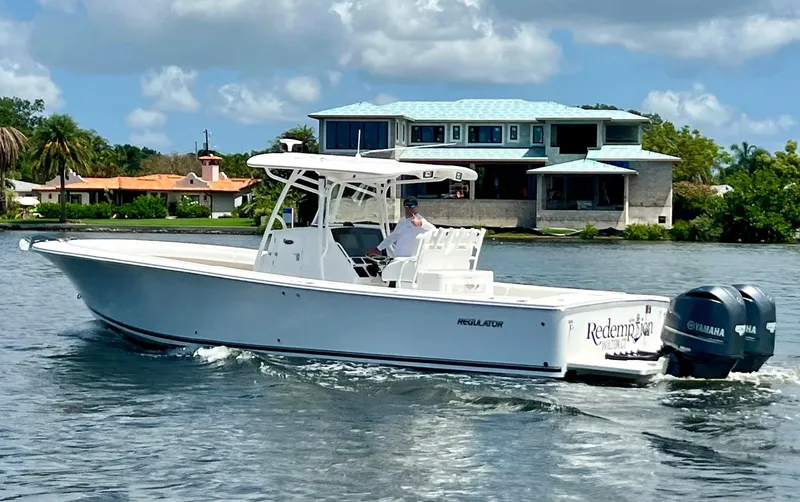 Redemption Yacht Photos Pics 2012 Regulator 34SS boat cruising on water near waterfront homes.