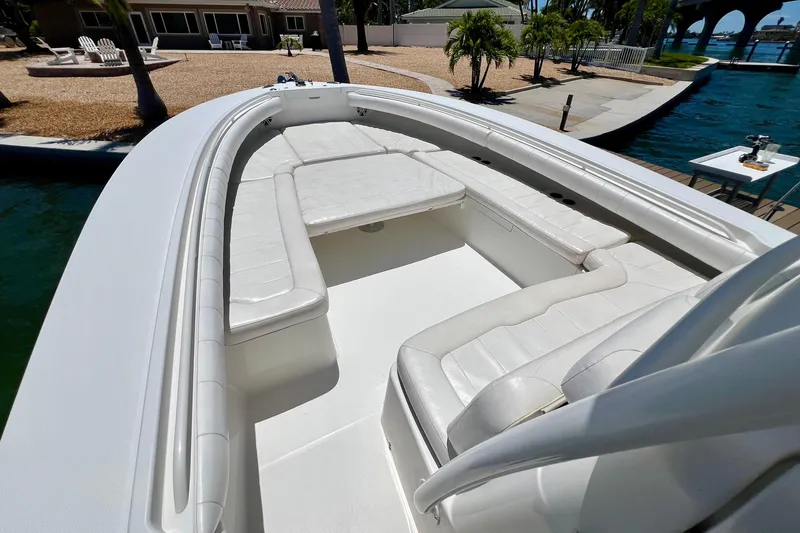 Redemption Yacht Photos Pics 2012 Regulator 34SS boat with white cushioned seating, docked near a waterfront property.