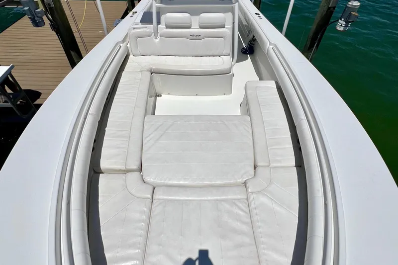 Redemption Yacht Photos Pics 2012 Regulator 34SS boat with white cushioned seating, docked by green water.