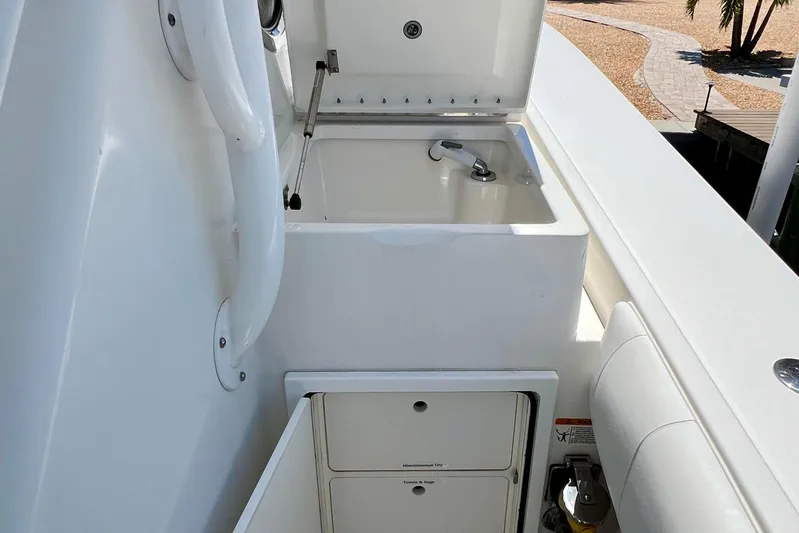 Redemption Yacht Photos Pics 2012 Regulator 34SS boat sink and storage area, featuring sleek white design.