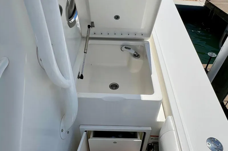 Redemption Yacht Photos Pics 2012 Regulator 34SS boat sink area with storage compartment, white finish.