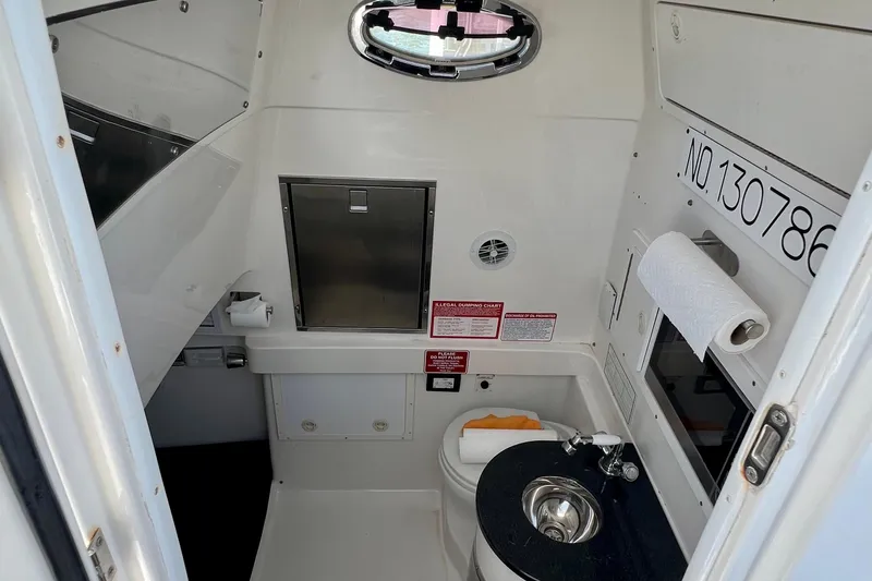 Redemption Yacht Photos Pics Interior of a 2012 Regulator 34SS boat featuring a compact bathroom with sink and toilet.