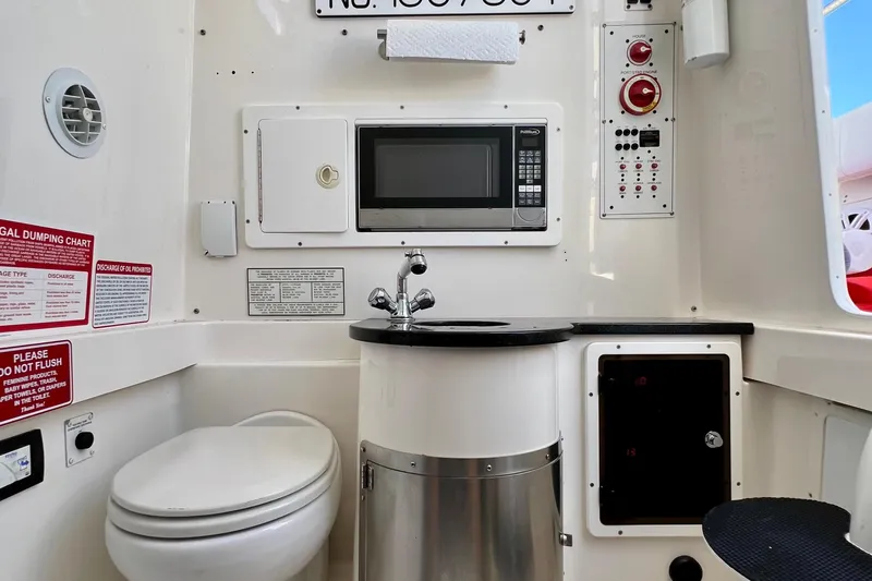Redemption Yacht Photos Pics 2012 Regulator 34SS boat interior with toilet, sink, microwave, and control panel.