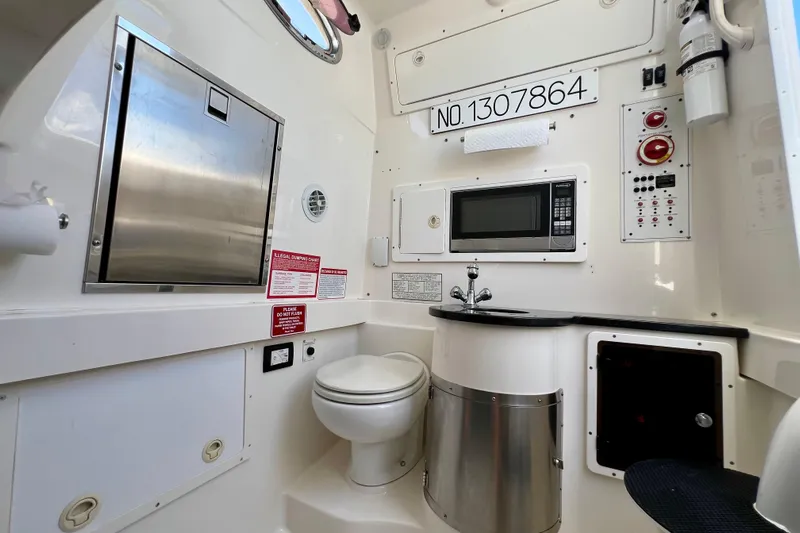 Redemption Yacht Photos Pics 2012 Regulator 34SS boat interior with toilet, sink, microwave, and control panel.