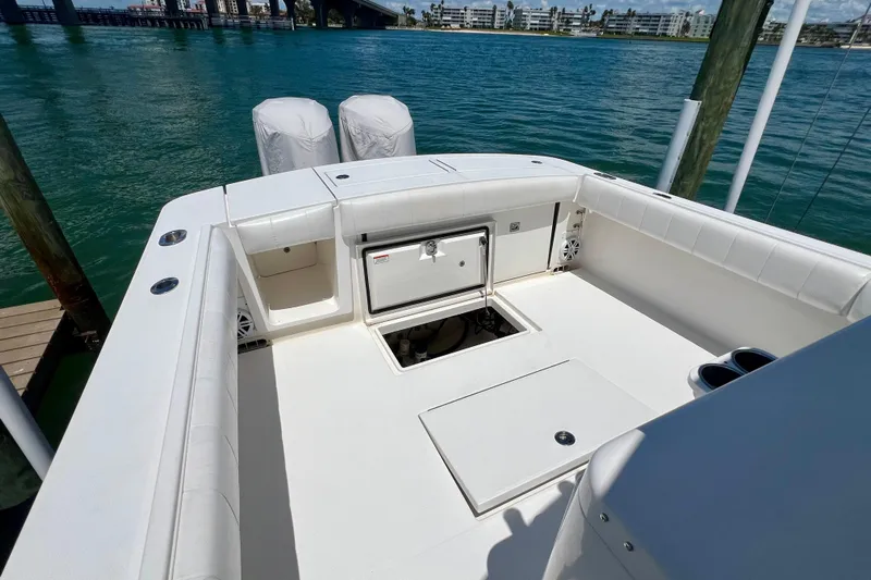 Redemption Yacht Photos Pics 2012 Regulator 34SS boat deck with storage compartments and twin engines, docked by clear water.