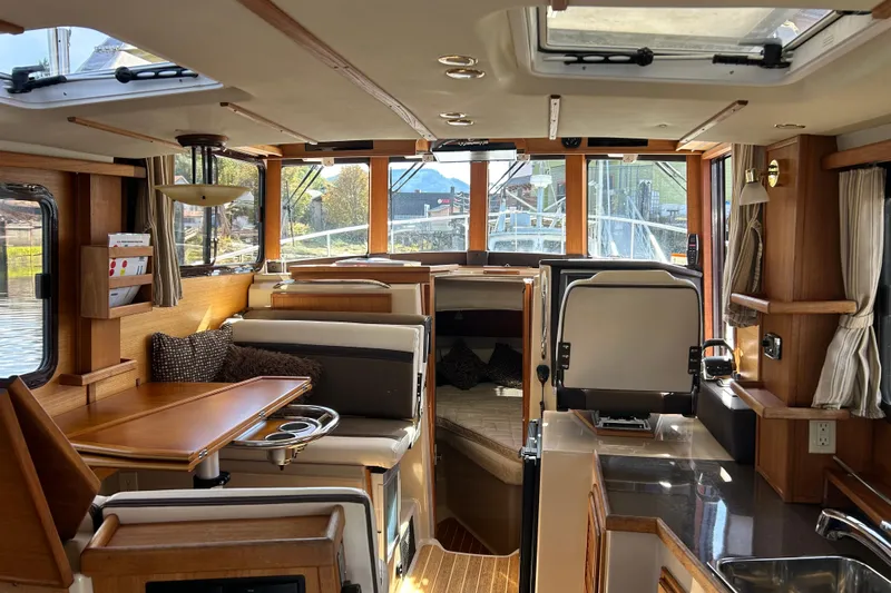  Yacht Photos Pics Interior of 2015 Rangr Tugs R-31 CB boat, featuring cozy seating and wooden finishes.