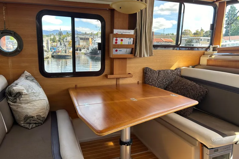  Yacht Photos Pics Cozy interior of 2015 Ranger Tugs R-31 CB with wooden table and scenic window view.