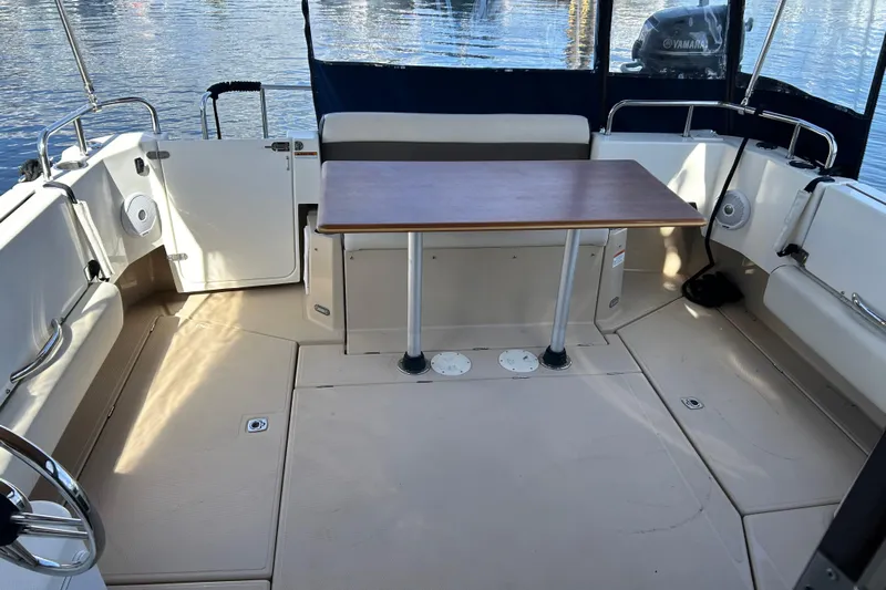  Yacht Photos Pics 2015 Ranger Tugs R-31 CB boat interior with seating and table, docked on calm water.