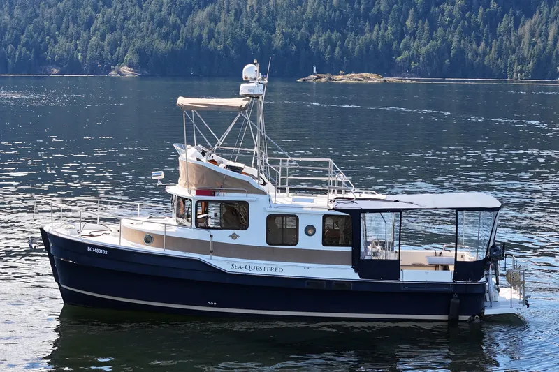  Yacht Photos Pics 2015 Rangr Tugs R-31 CB boat on calm water with forested background.