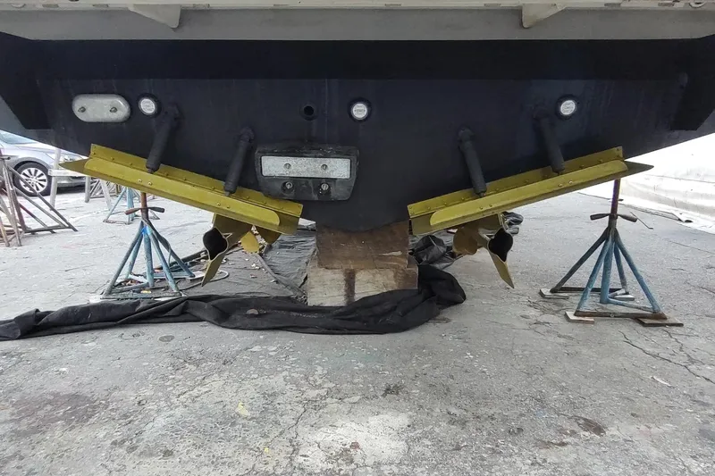 Me Yacht Photos Pics Rear view of 2021 Regal 42 Fly boat on stands, showing propellers and trim tabs.