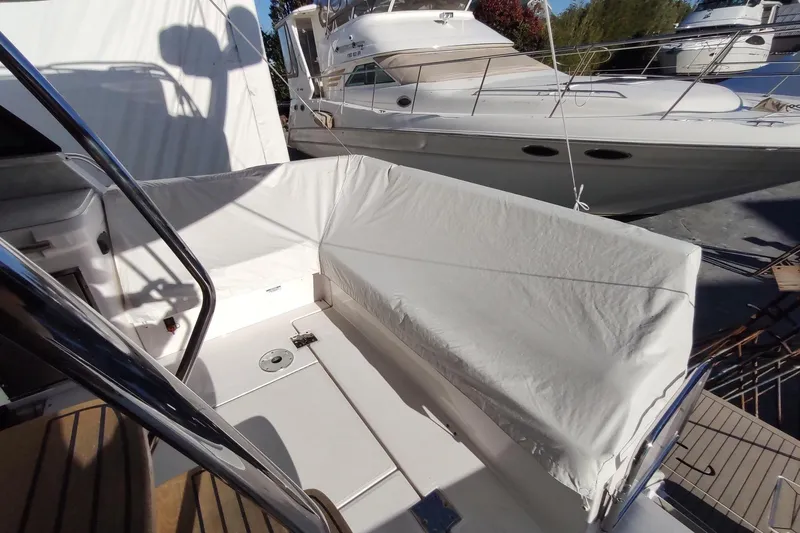 Me Yacht Photos Pics 2021 Regal 42 Fly yacht with covered seating area, docked alongside another boat.