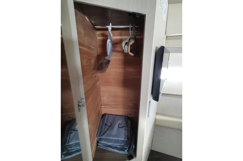 Me Yacht Photos Pics Wooden closet interior on a 2021 Regal 42 Fly yacht, featuring hangers and storage bags.