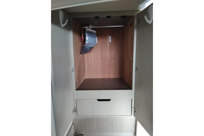 Me Yacht Photos Pics 2021 Regal 42 Fly yacht interior closet with wooden finish and storage drawer.