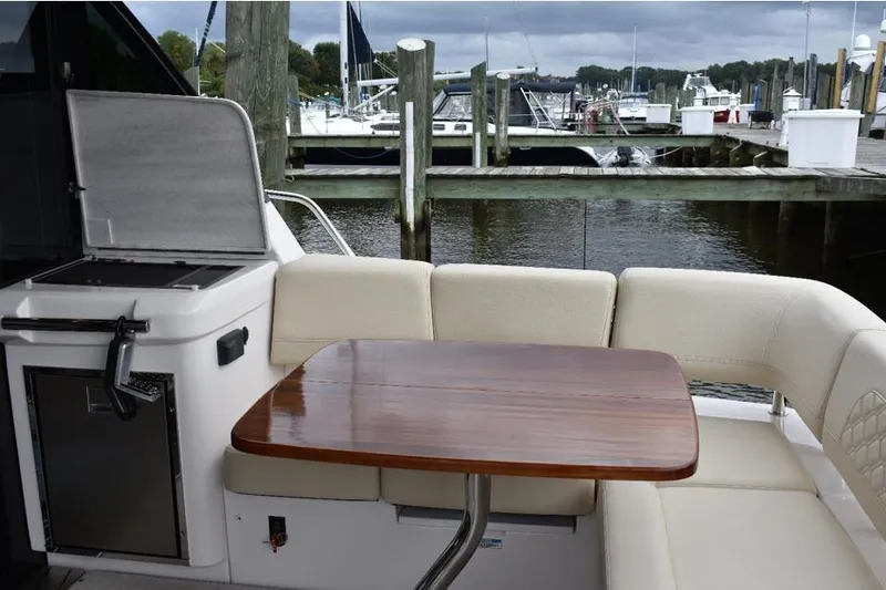 Me Yacht Photos Pics Luxurious seating area on 2021 Regal 42 Fly yacht with wooden table and marina view.