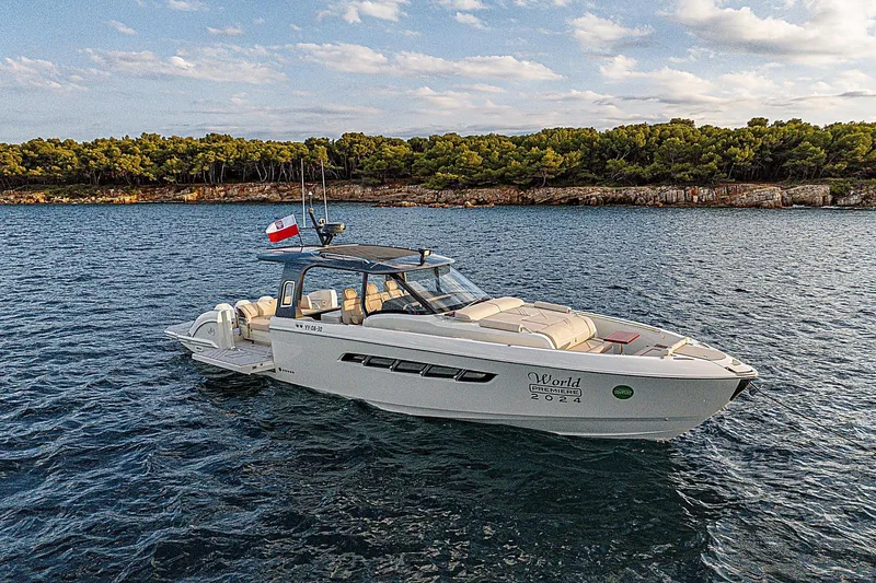  Yacht Photos Pics 2024 Wiszniewski Yachts W43 cruising on serene waters near a forested coastline.