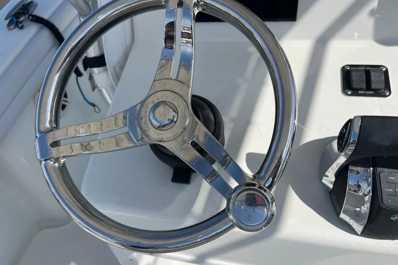  Yacht Photos Pics Steering wheel of 2019 Yellowfin 29 Offshore boat, featuring sleek chrome design.