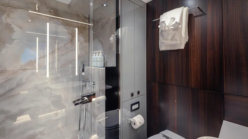 Hideout Yacht Photos Pics Luxurious bathroom in 2025 Sunseeker 88 Yacht with marble and wood finishes.