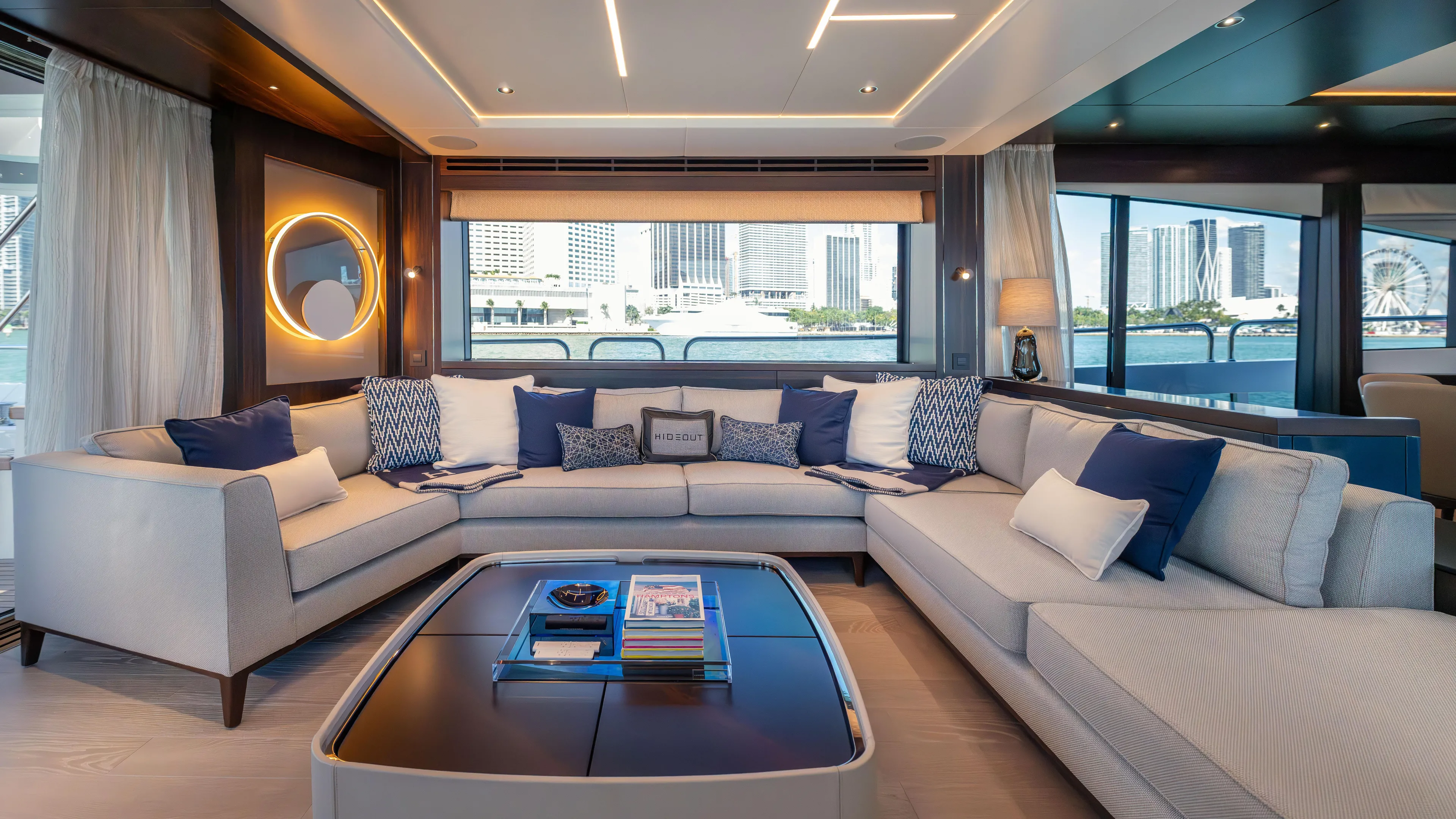 Hideout Yacht Photos Pics Luxurious interior of 2025 Sunseeker 88 Yacht with elegant seating and cityscape view.