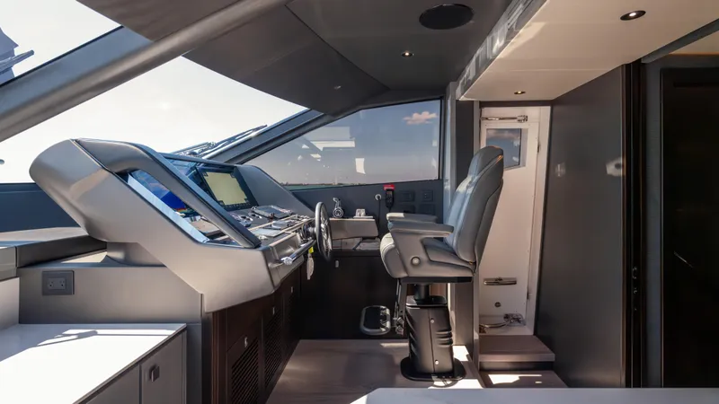 Hideout Yacht Photos Pics Interior helm of 2025 Sunseeker 88 Yacht, featuring modern navigation controls and seating.