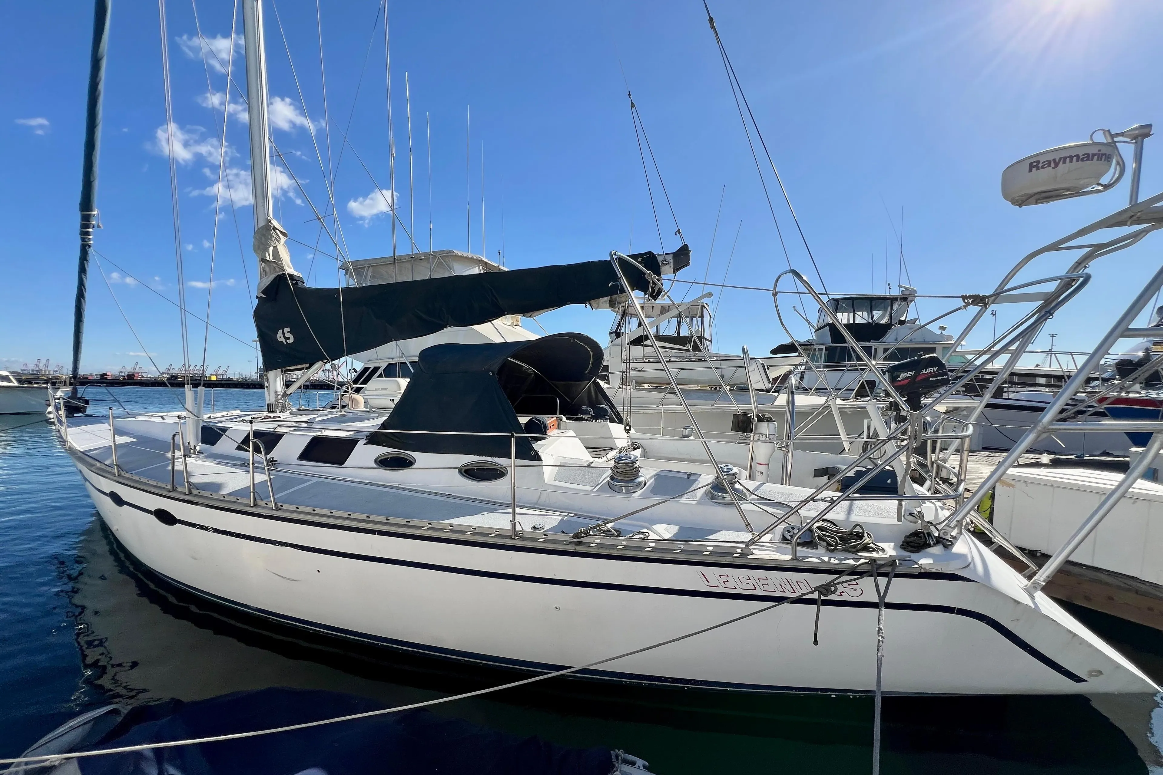 1986 Hunter Legend 45 sailboat docked in marina under clear blue sky.