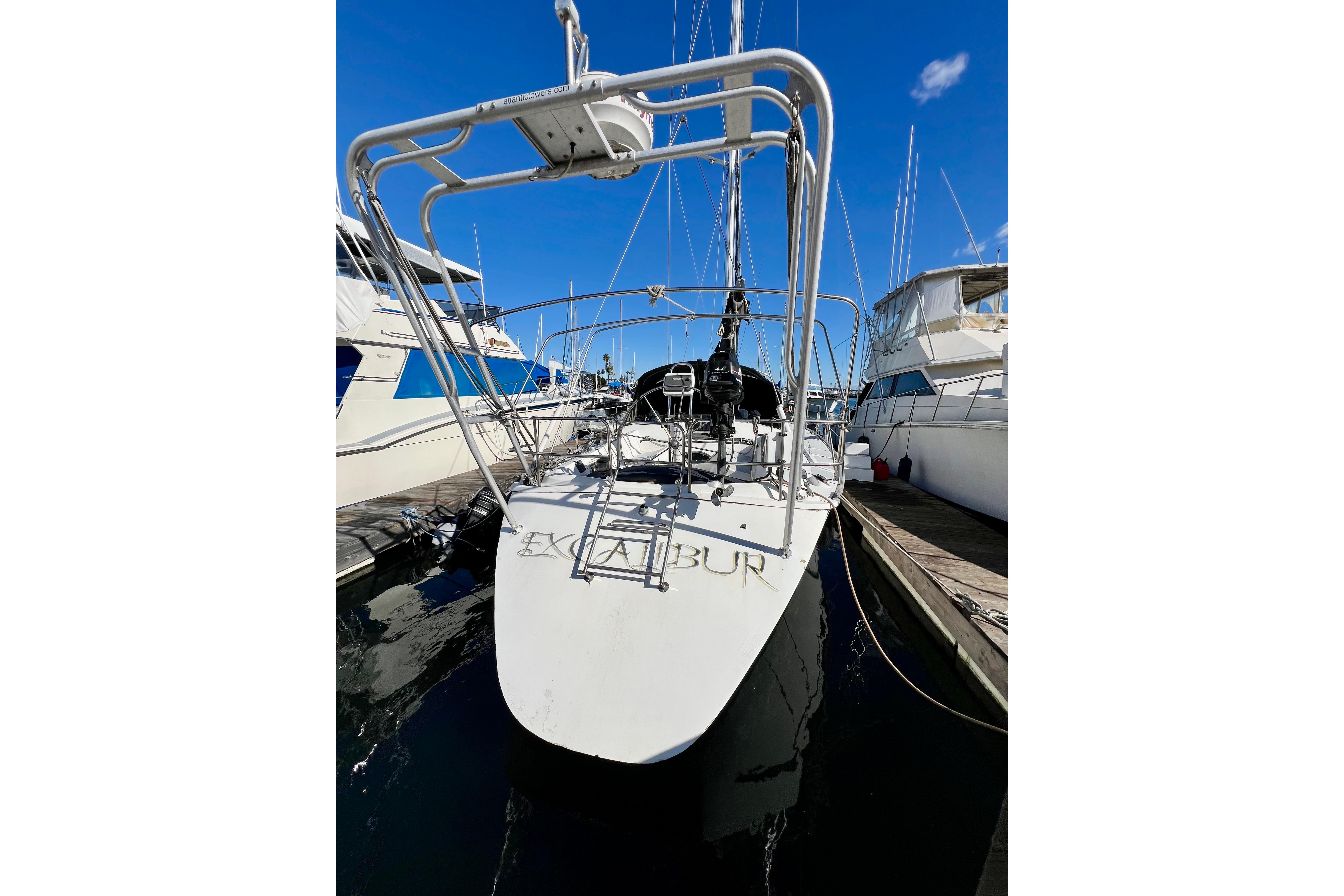 1986 Hunter Legend 45 sailboat docked at marina under clear blue sky.