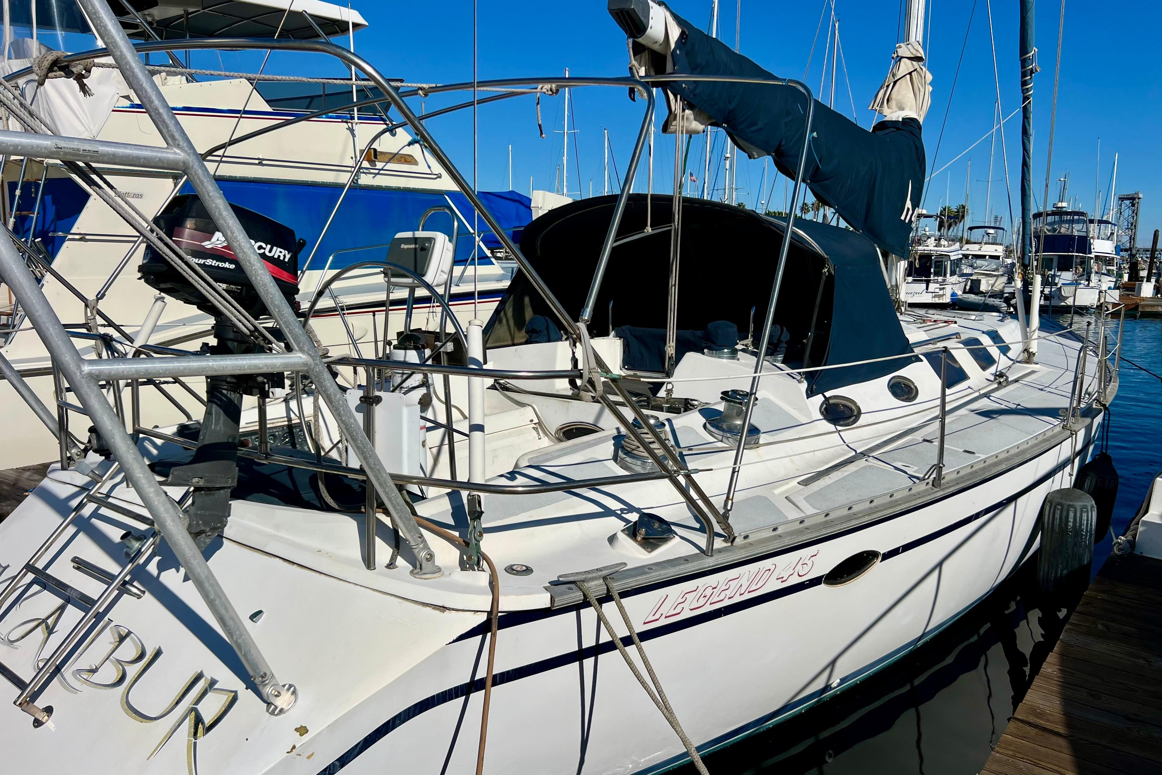 1986 Hunter Legend 45 sailboat docked at marina, featuring a sleek design and Mercury outboard motor.