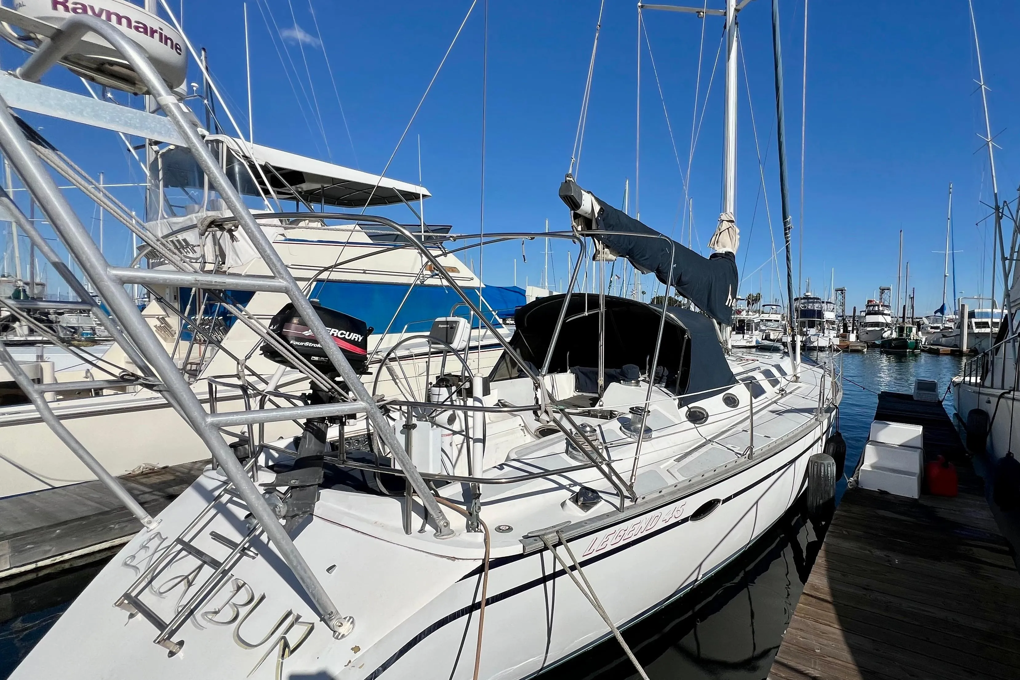 1986 Hunter Legend 45 sailboat docked at marina under clear blue sky.