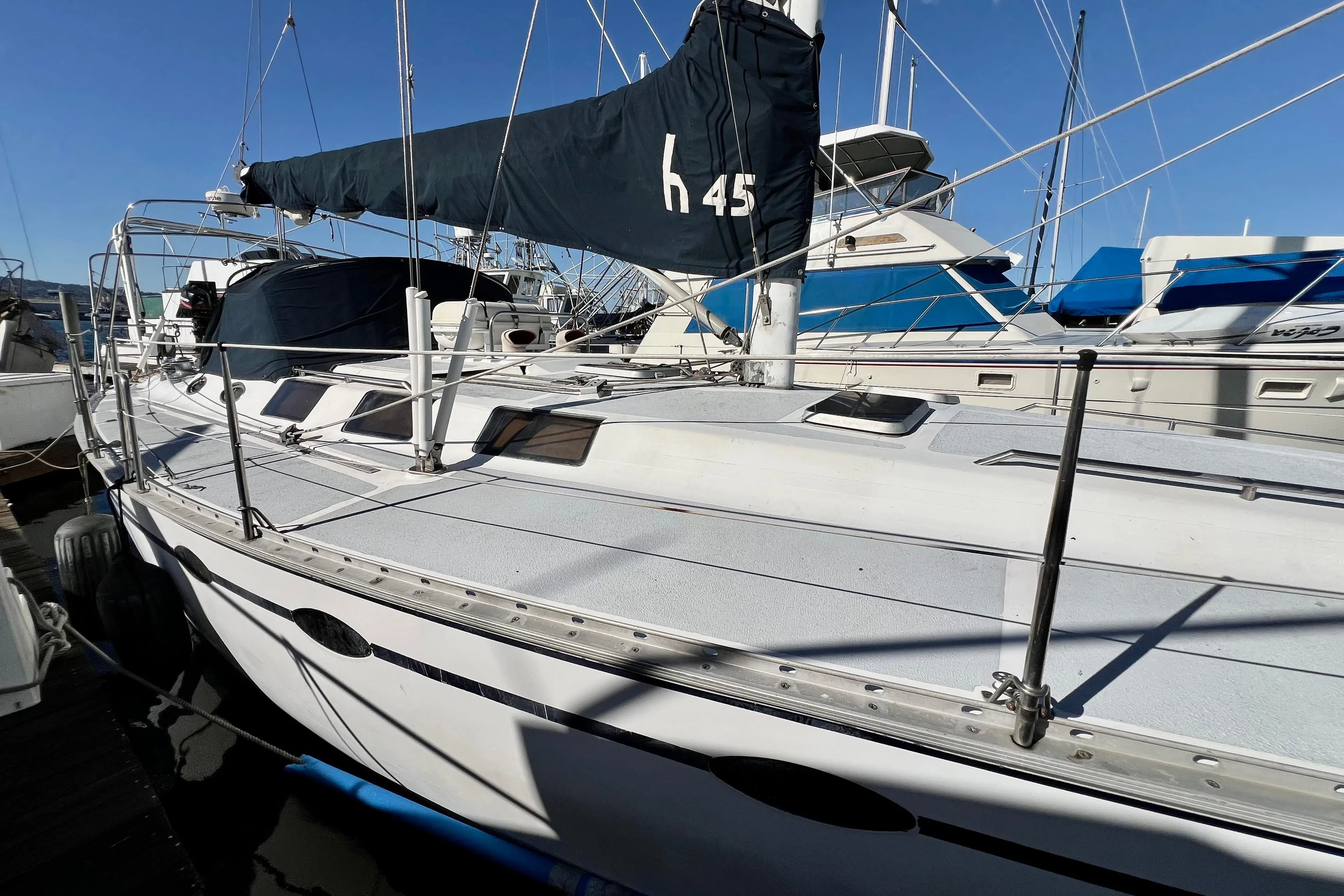 1986 Hunter Legend 45 sailboat docked at marina, featuring sleek design and blue sail cover.